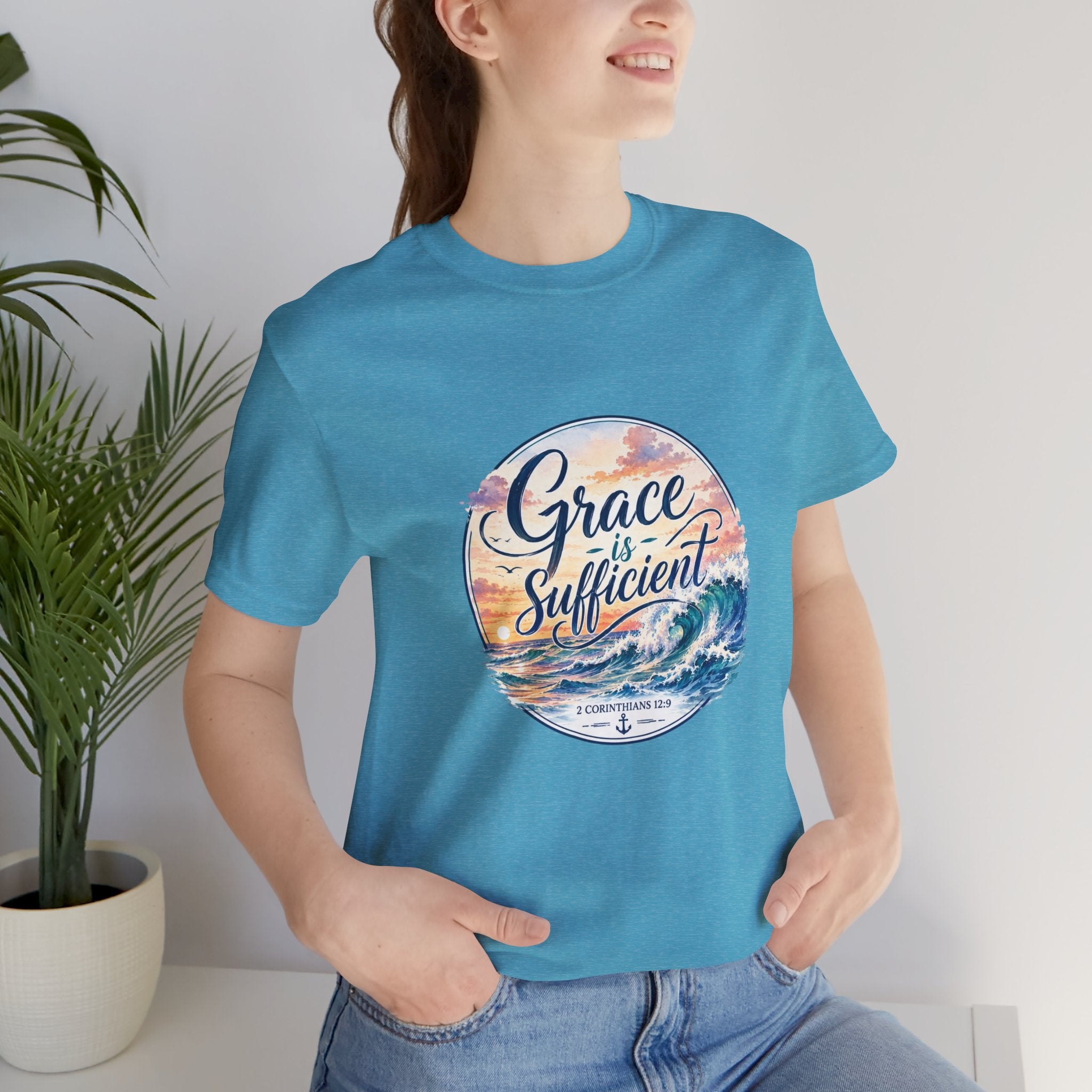 Grace Is Sufficient Tee worn by a smiling woman, featuring a seaside design and pastel colors.