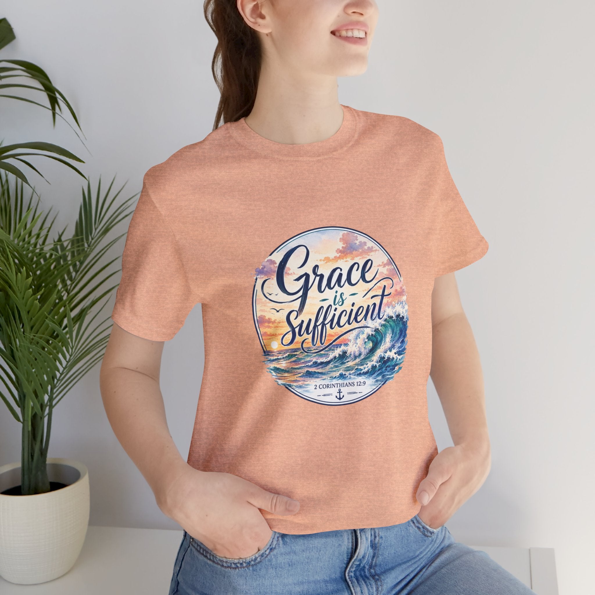 Woman wearing a Grace Is Sufficient Tee with a soothing seaside design, featuring pastel colors and ocean wave graphics.